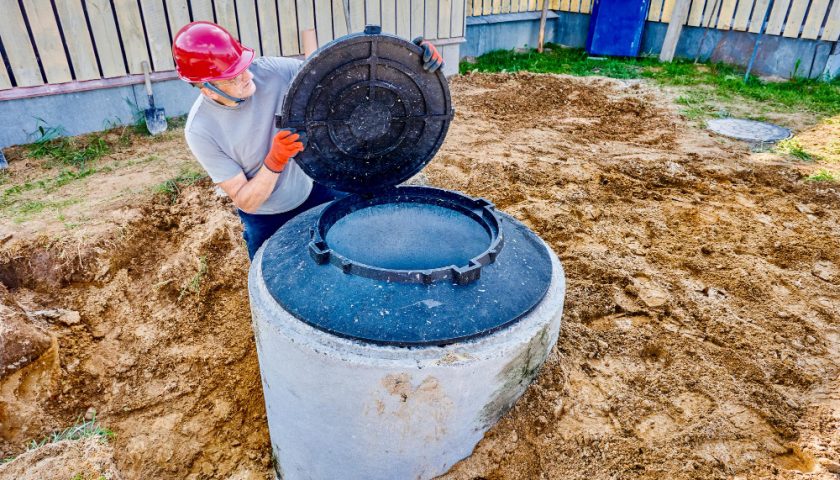 un homme ouvrant une fosse sceptique