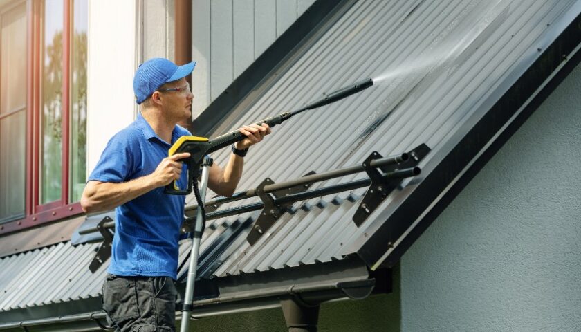homme nettoyant un toit avec un karcher