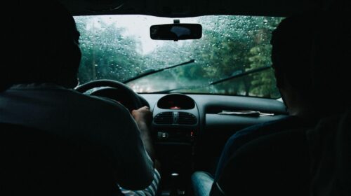 deux hommes en voiture roulant sous la pluie