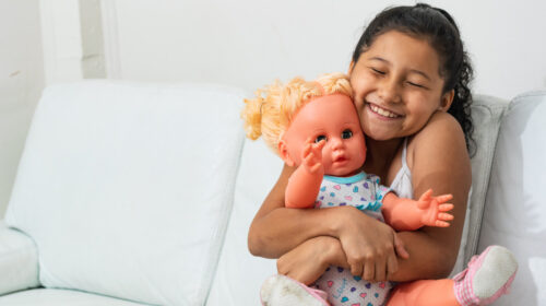 une petite fille serrant une poupée dans ses bras